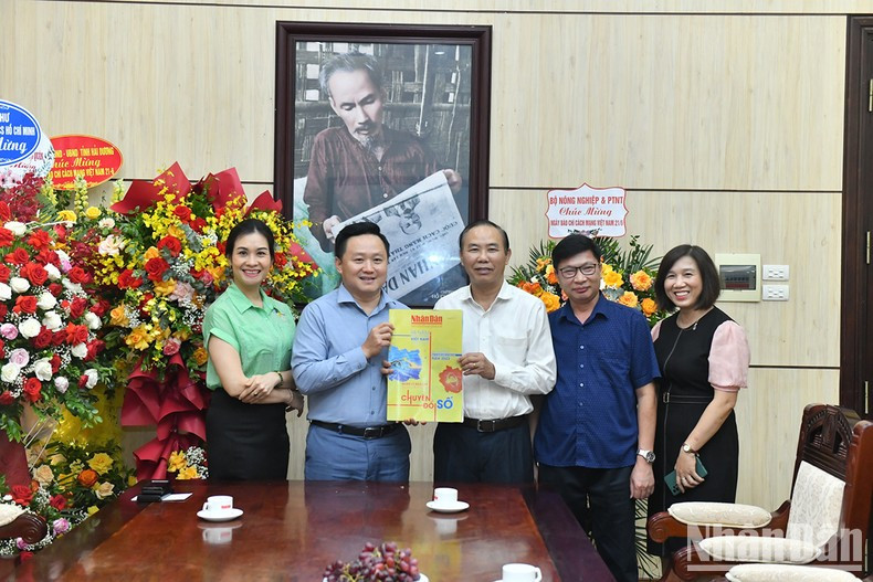 《人民报》社副总编辑潘文雄向农业与农村发展部副部长冯德进赠送纪念越南革命新闻日98周年特刊。（登科 摄）