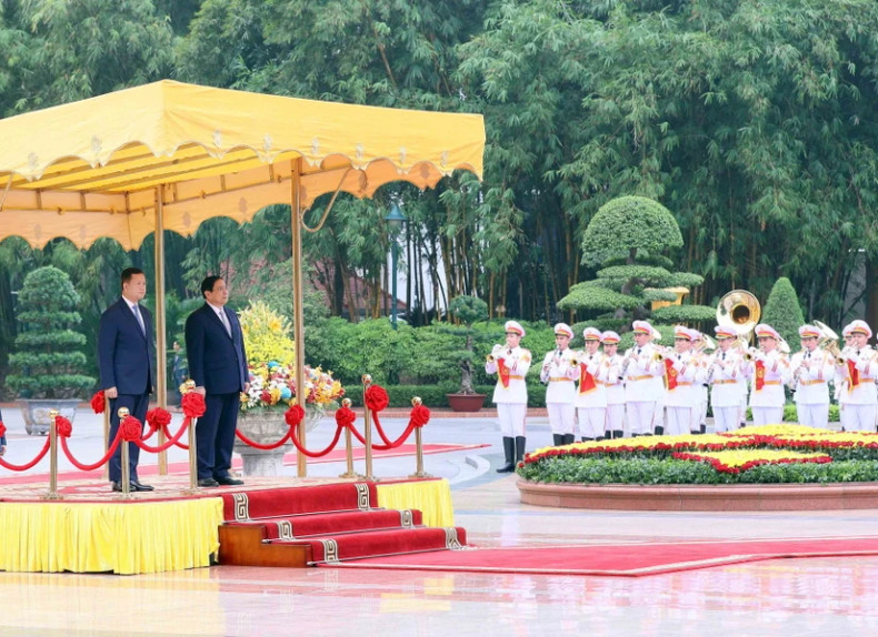 范明正总理和洪玛奈首相登上检阅台,军乐团奏响两国国歌。(图片来源:越通社) 范明正总理和洪玛奈首相登上检阅台,军乐团奏响两国国歌。(图片来源:越通社)