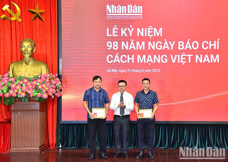 黎国明总编辑授予越南新闻工作者协会纪念章。