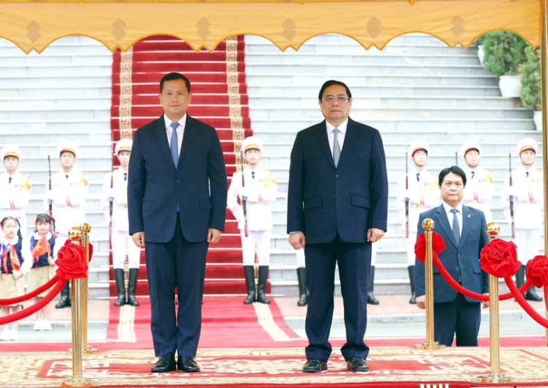 范明正总理和洪玛奈首相登上检阅台,军乐团奏响两国国歌。(图片来源:越通社) 范明正总理和洪玛奈首相登上检阅台,军乐团奏响两国国歌。(图片来源:越通社)