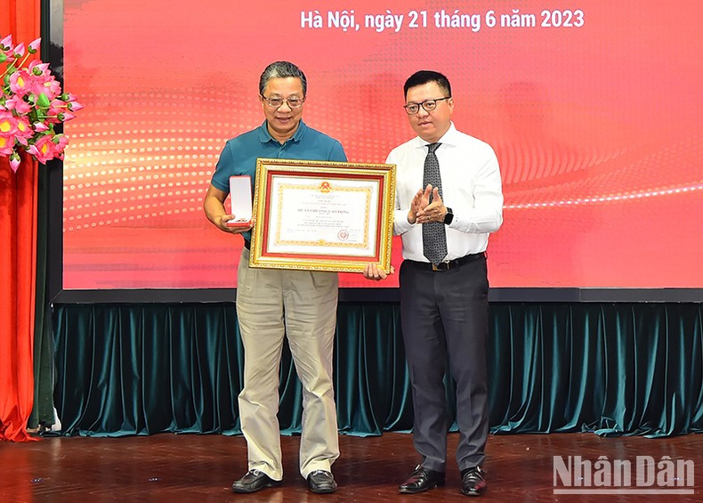 《人民报》社总编辑黎国明向《人民报》社编委会前委员陈越强授予国家主席二级劳动勋章。