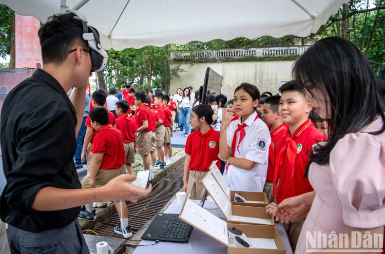 组委会代表指导学生们体验增强现实眼镜，观看河内的3D图像。