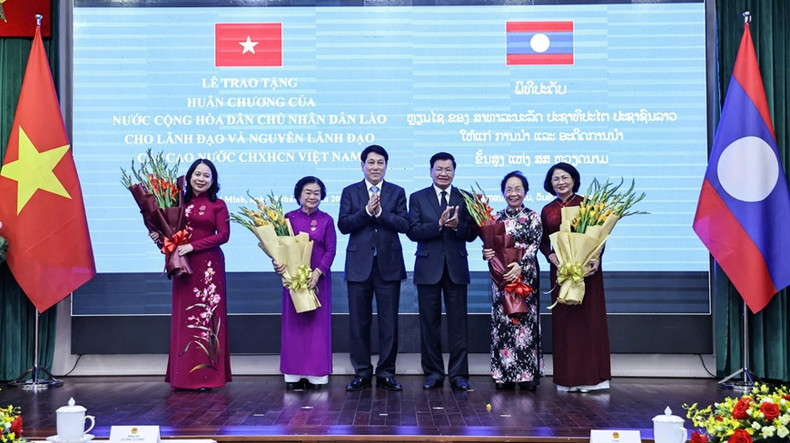 越南国家主席梁强与老挝国家主席通伦·西苏里向荣获勋章的各位同志赠送鲜花。 越南国家主席梁强与老挝国家主席通伦·西苏里向荣获勋章的各位同志赠送鲜花。