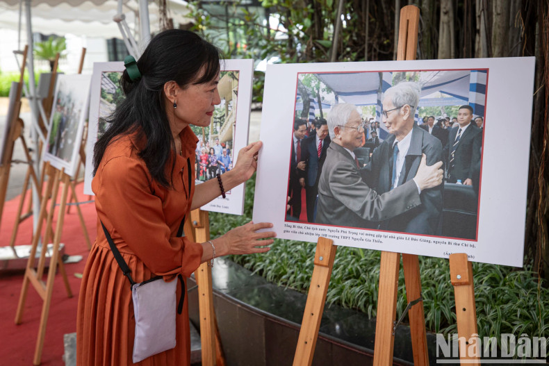 人们欣赏由人民报记者拍摄的阮富仲总书记与黎德江老师的图片。