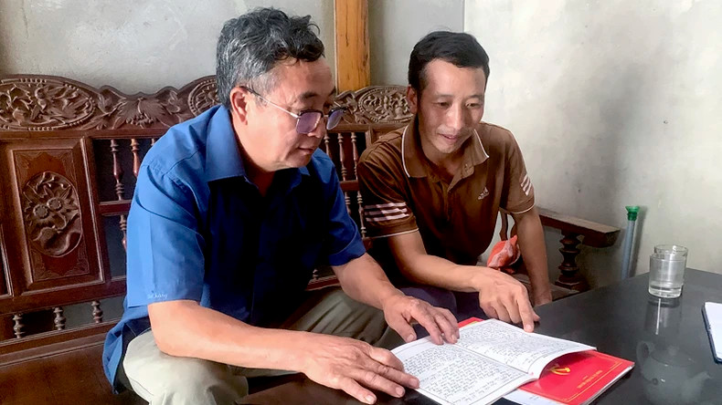 安山县雄利乡纳丧村党支部书记楼文泰（左）与年轻党员进行交谈。