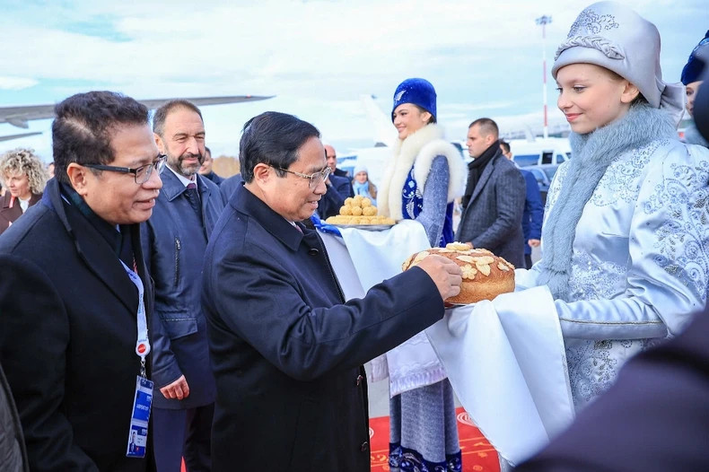 俄罗斯女孩邀请范明正总理享用盐面包，这是该国欢迎贵宾的传统习俗。