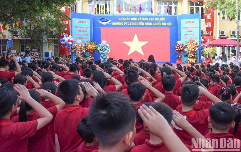 与会代表和师生们向国旗敬礼。 与会代表和师生们向国旗敬礼。