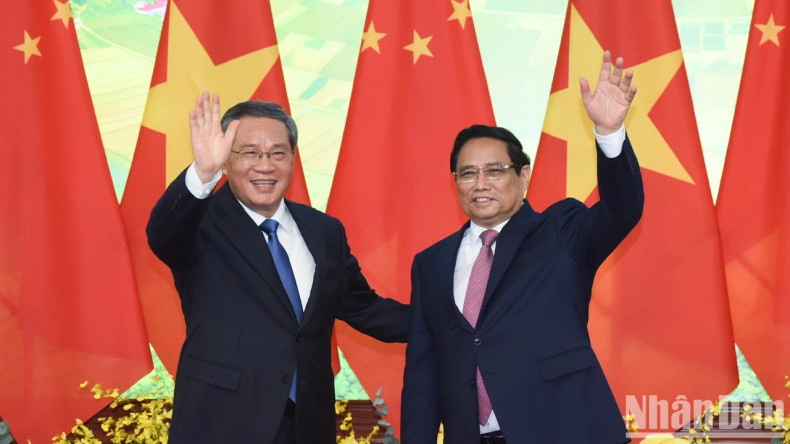 越南政府总理范明正同中国国务院总理李强向新闻媒体记者挥手致意。