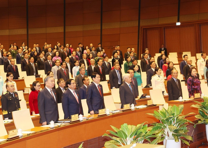 越共中央总书记、国家主席苏林，党和国家领导、前领导，与会代表在越南第十五届国会第八次会议开幕式上向国旗敬礼。（图片来源：越通社）