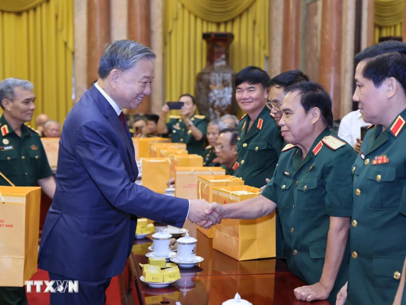 越共中央总书记、越南国家主席苏林和308师老战士代表握手。（图片来源：越通社）