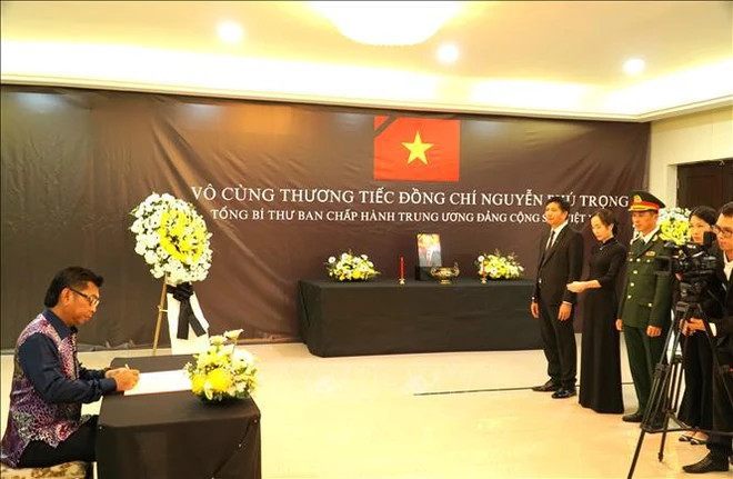 马来西亚外交部副部长穆罕默德·本·阿拉明在吊唁簿上留言。（图片来源：越通社）