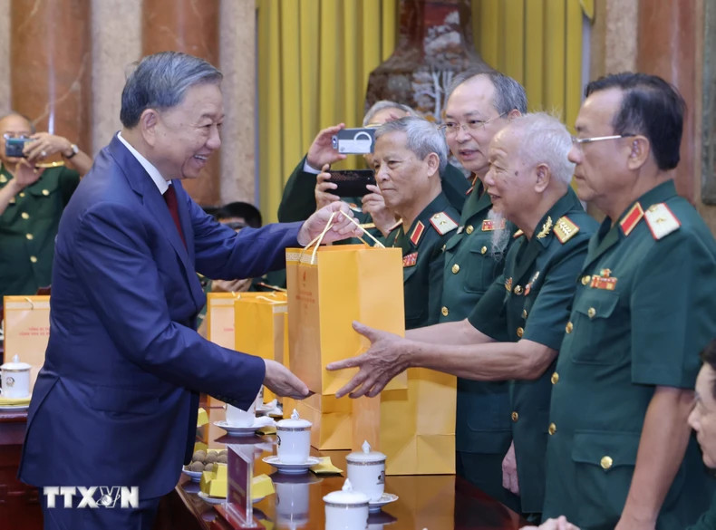 越共中央总书记、越南国家主席苏林向308师老战士代表送礼物。（图片来源：越通社）