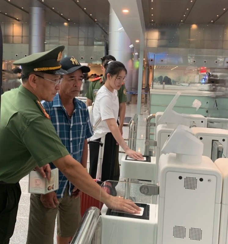 职能单位指导游客通过自动关卡扫描护照。