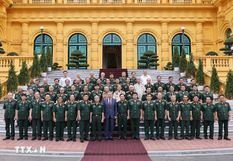 越共中央总书记、越南国家主席苏林和308师老战士代表团合影。（图片来源：越通社）