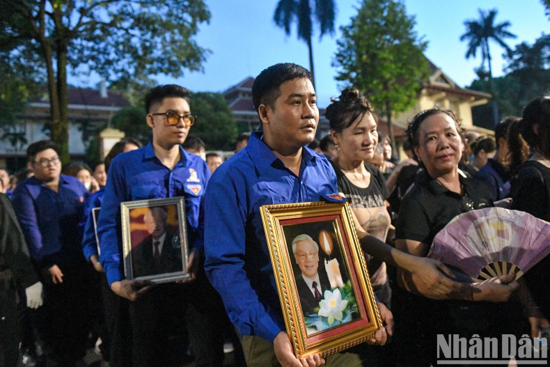 许多人手上抱着阮富仲总书记的遗像。 许多人手上抱着阮富仲总书记的遗像。