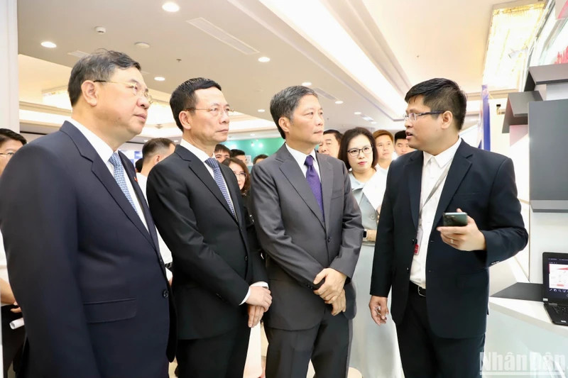 越共中央政治局委员、中央经济部部长陈俊英，越共中央委员、通信传媒部部长阮孟雄和南定省委书记范家宿参观各展位。