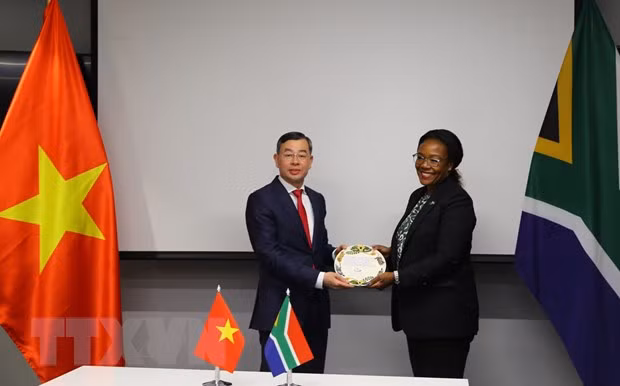 越南国家审计署审计长吴文俊接收南非审计署审计长察卡尼·马卢莱克赠送的纪念品。（图片来源：越通社）