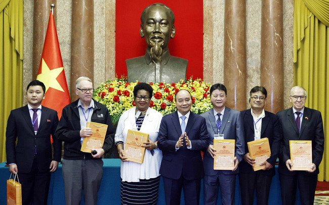 国家主席阮春福向世界和平理事会第22届大会参会代表赠送礼物。（图片来源：越通社）