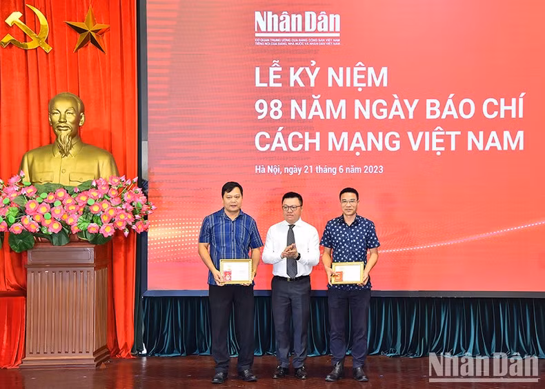 黎国明总编辑授予越南新闻工作者协会纪念章。