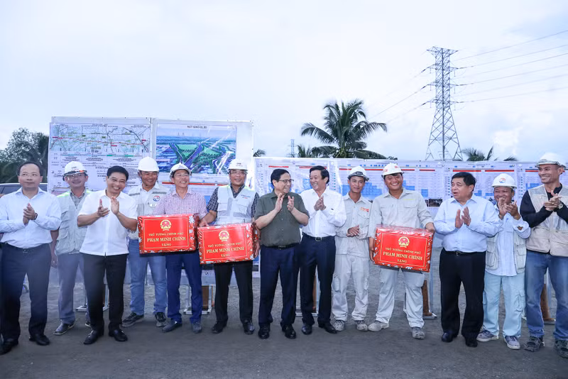 越南政府总理范明正向美顺二号大桥的工程师和工人送礼物。（图片来源：VGP）