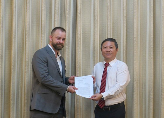 胡志明市人民委员会副主席杨英德和保罗·哈金斯先生。（图片来源：西宫解放报）