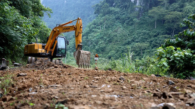 林平县建设投资项目管理委员会动用挖掘机平整道路上的侵蚀点。