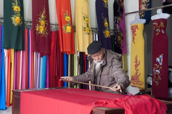 泽舍手工艺村艺人裁缝奥黛。（图片来源：duyendangvietnam.net）