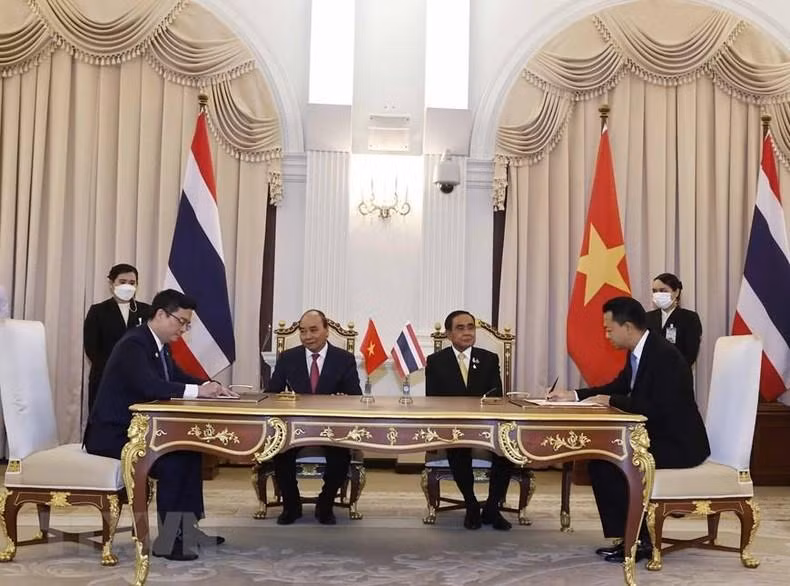 越南国家主席阮春福同泰国总理巴育·占奥差见证越南外贸股份商业银行与泰国进出口银行的合作协议签署仪式。