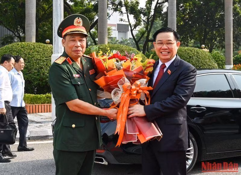 国防学院院长陈越科上将向国会主席王廷惠赠送鲜花。