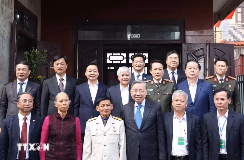 苏林总书记和各位代表同人民武装力量英雄丁国防及家属合影。