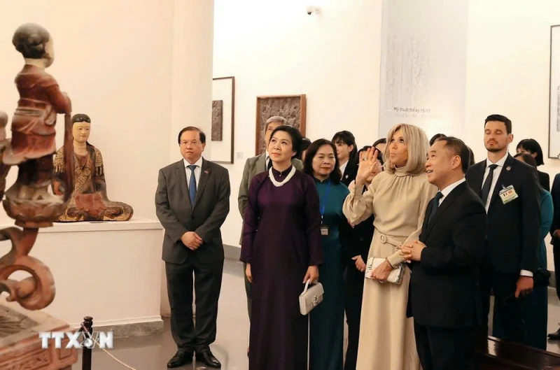 越共中央总书记苏林夫人吴芳璃与法国总统夫人布丽吉特·马克龙参观越南美术博物馆。（图片来源：越通社）