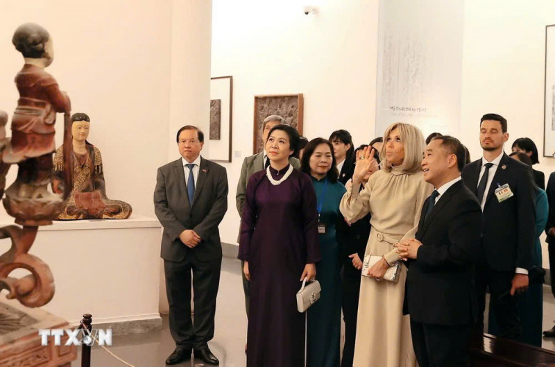 越共中央总书记苏林夫人吴芳璃与法国总统夫人布丽吉特·马克龙参观越南美术博物馆。（图片来源：越通社）