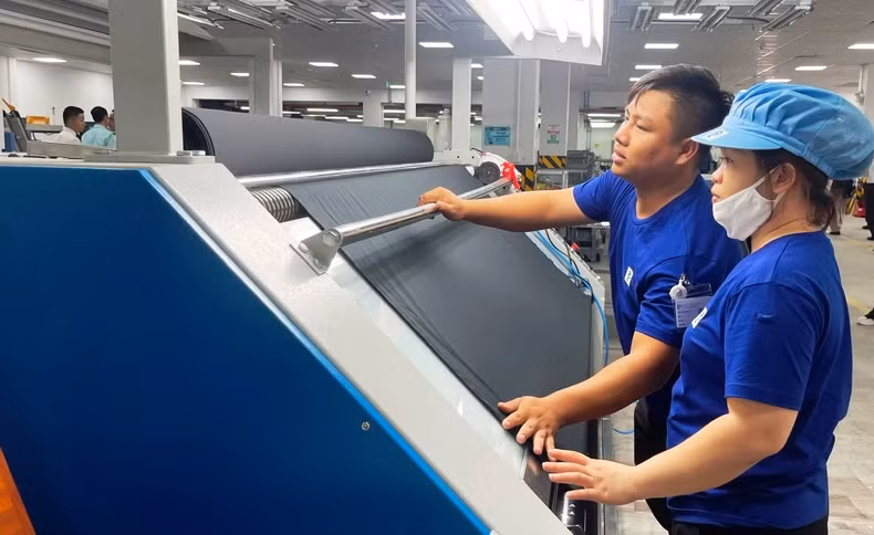 工人们在南定省义兴县亮东纺织服装工业区的 TOP TEXTILES 纺织印染厂工作。（春长 摄）