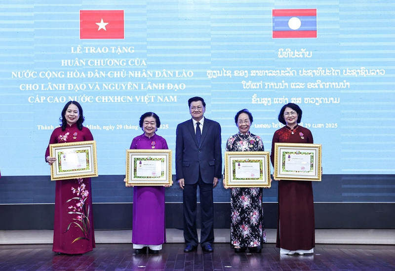 老挝国家主席通伦·西苏里向越南国家副主席武氏映春及几位前任副主席颁授一级自由勋章。（图片来源：qdnd.vn）