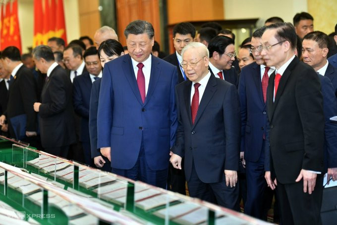 越共中央总书记阮富仲和中共中央总书记，国家主席习近平观看两国签署的合作文件。（图片来源：vnexpress.net）