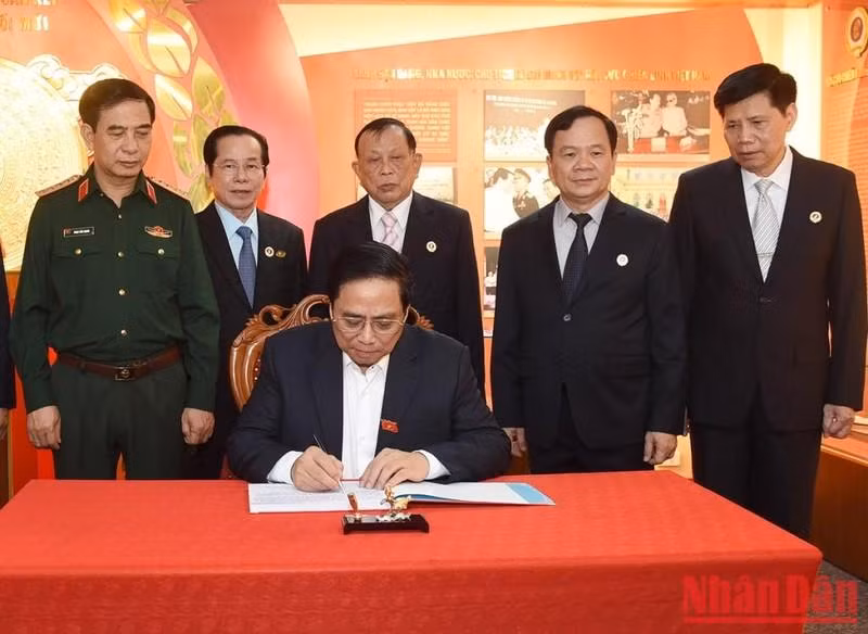 范明正总理在越南老战士协会的传统金本子上留言。