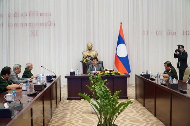 老挝人民革命党中央委员会总书记、国家主席通伦·西苏里会见援老越南专家和志愿军代表团。（图片来源：越通社）