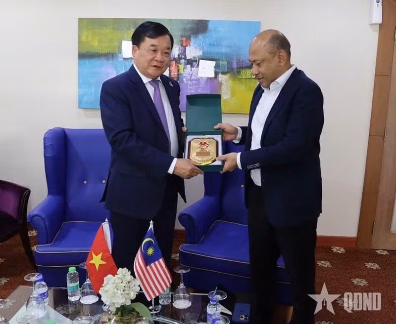 越南国防部副部长黄春战上将向马来西亚国防部副秘书长雅尼赠送纪念品。（图片来源：qdnd.vn）