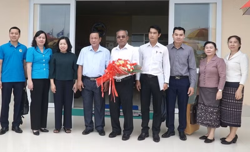 越南劳动总联合会常务副主席蔡秋昌和老挝中央工会联合会高级代表团合影。（图片来源：laodong.vn）