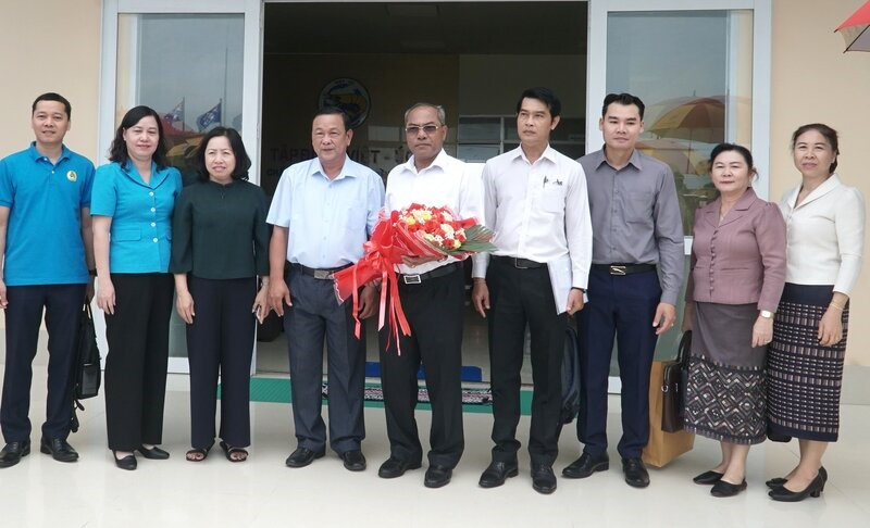 越南劳动总联合会常务副主席蔡秋昌和老挝中央工会联合会高级代表团合影。（图片来源：laodong.vn）