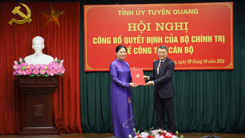 黎明兴同志向何氏娥同志授予决定书。
