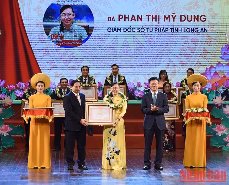 范明正总理向在响应越南法律10年来取得优秀成绩的个人颁发奖状。