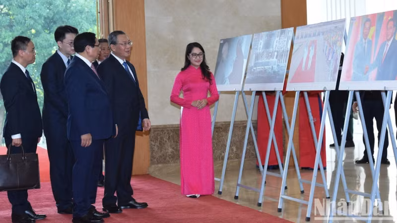 越南政府总理范明正向中国国务院总理李强介绍有关越中合作的图片。