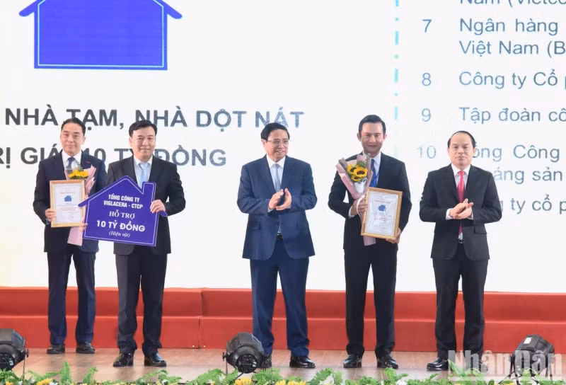 政府总理范明正和谅山省委书记阮国团向谅山省解决临时性房屋和破旧房子计划赞助商颁发证书。