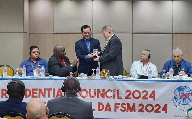 越南劳动总联合会主席、世界工会联合会主席团理事会副主席阮廷康向世界工会联合会领导赠送礼物。（图片来源：越通社）