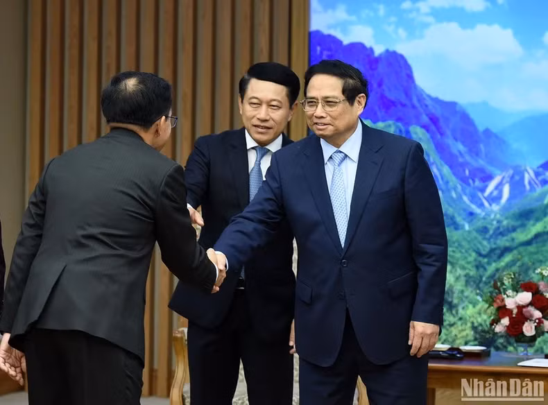 越南政府总理范明正欢迎陪同老挝政府副总理兼外交部长沙伦塞·贡马西的老方代表团成员。