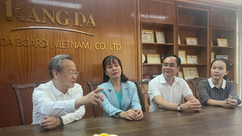 中国《人民日报》社总编辑陈建文同志和西宁省委常务委员会委员、省委宣教与民运部部长阮氏春香交谈。