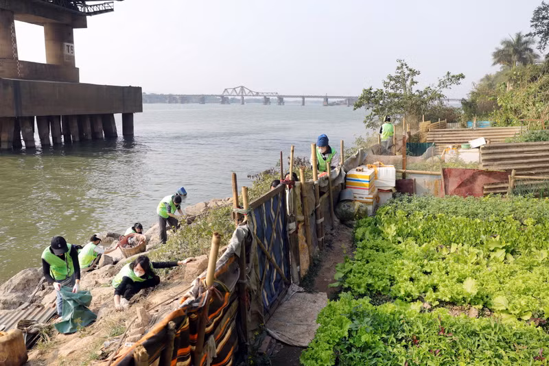 越南保洁队成员在章阳桥下收拾垃圾。 越南保洁队成员在章阳桥下收拾垃圾。