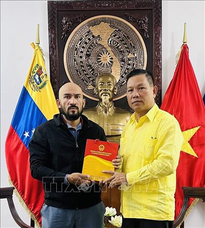 越南驻委内瑞拉大使向何塞·哈维尔·迪亚斯·马卡丹教授赠送纪念品。（图片来源：越通社）