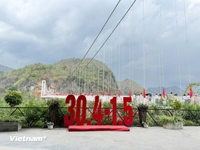 为纪念越南南方解放、国家统一50周年，玻璃桥沿线悬挂金星红旗。 （图片来源：越通社）